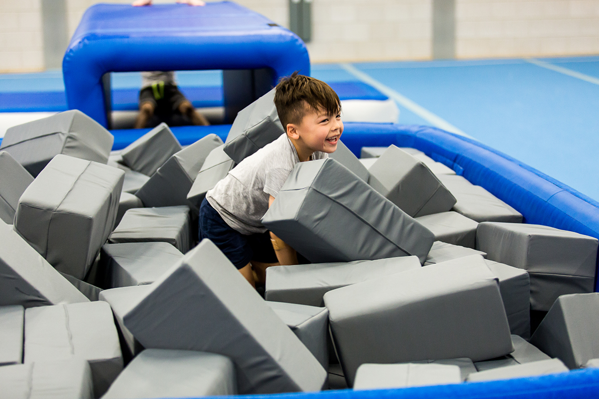 Boy playing with foam for airpit Airgym